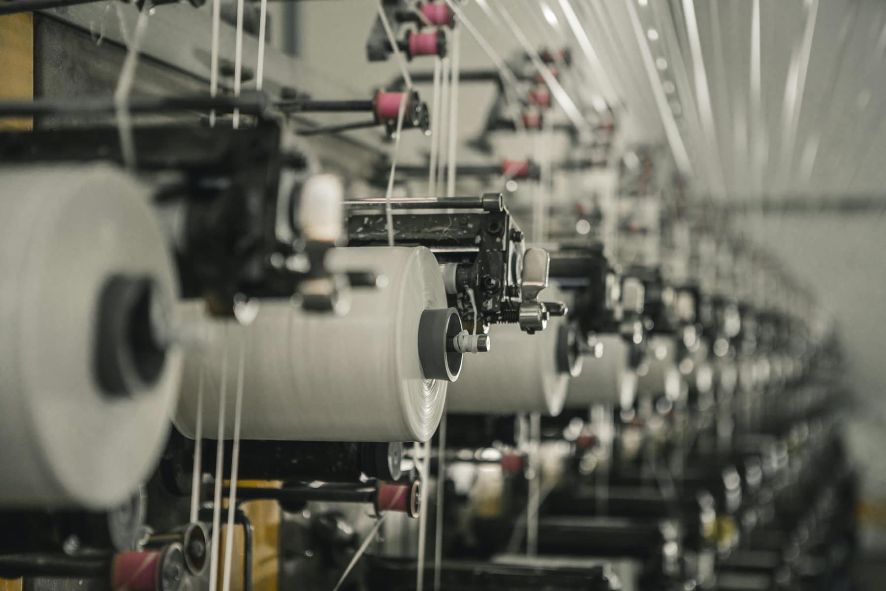 Des bobines de fil sur les métiers d’une filature
